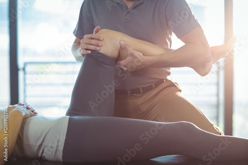 Photography Physiotherapist giving knee therapy to a woman