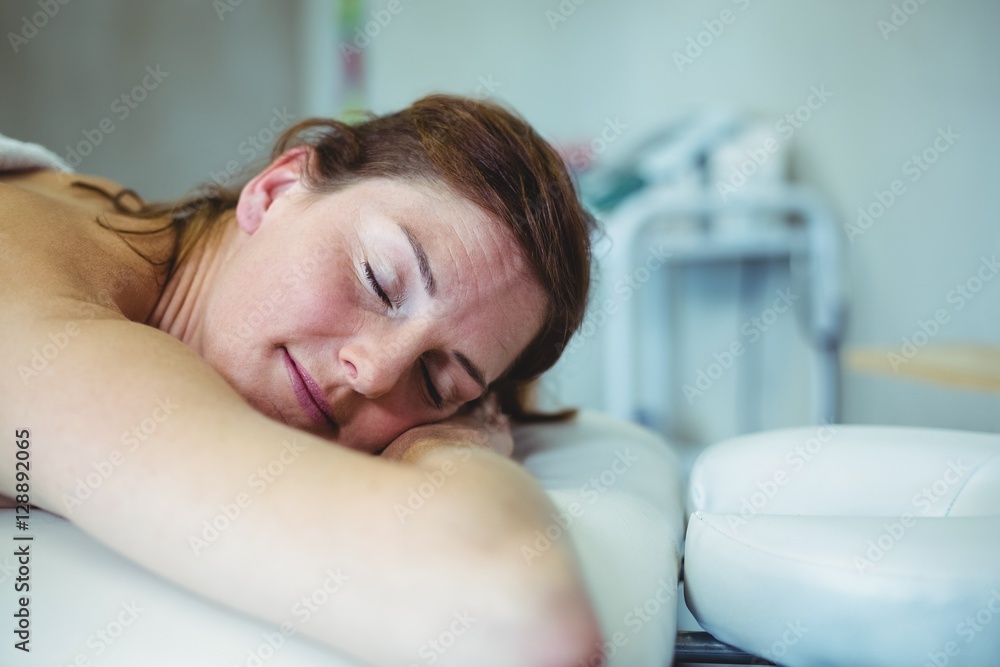 Woman relaxing on examination bed while taking massage Woman relaxing on examination bed while taking massage