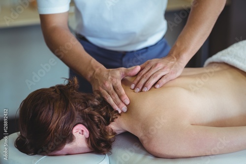 Physiotherapist giving neck massage to a woman