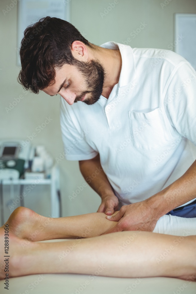 Fototapeta premium Physiotherapist giving leg massage to a woman