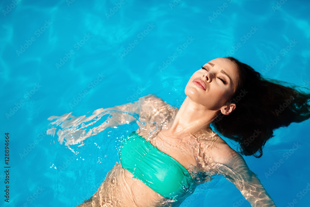 Beautiful female enjoying swimming pool