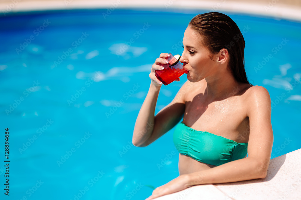 Woman enjoying cocktail at pool
