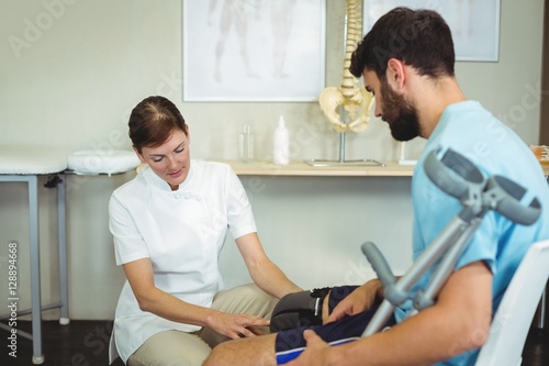 Physiotherapist examining patients knee