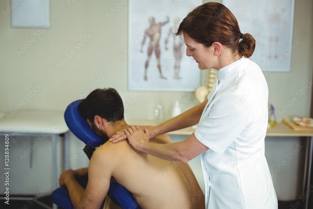 Physiotherapist giving back massage to a patient Physiotherapist giving back massage to a patient