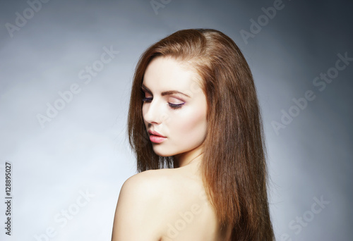 Beauty portrait of a young woman on grey