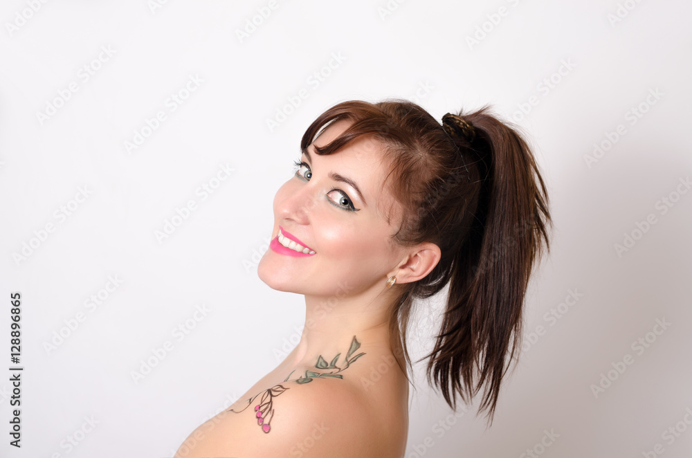 portrait of young beautiful woman with a picture on her body on a gray background