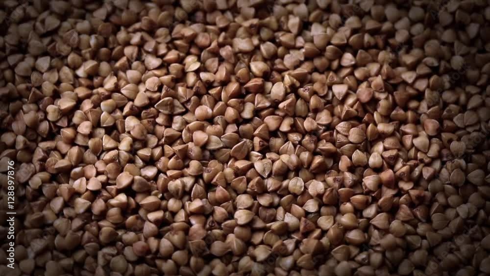 Rotating raw buckwheat. Spinning closeup dry uncooked seeds Rotating raw buckwheat. Spinning closeup dry uncooked seeds