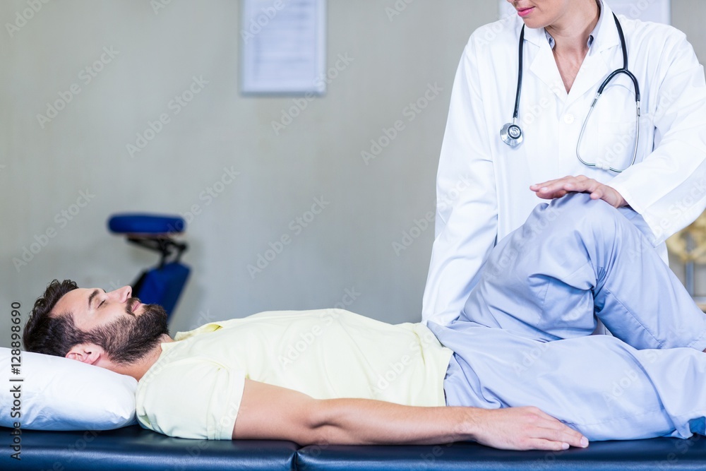 Female physiotherapist giving knee massage to male patient Female physiotherapist giving knee massage to male patient