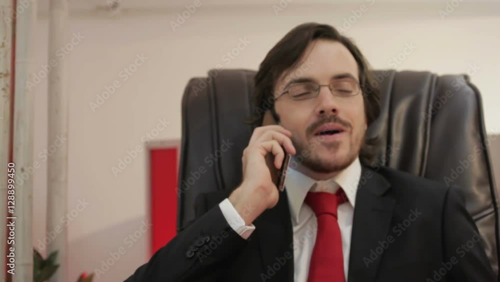 Elegant businessman sitting on the leather chair talking on the smarthphone Elegant businessman sitting on the leather chair talking on the smarthphone