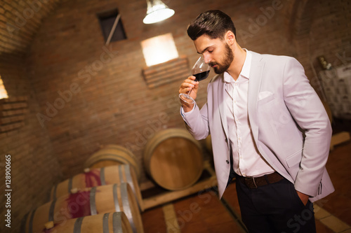 Tapeta Winemaker inspecting wine in basement