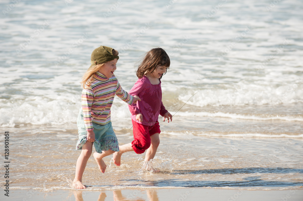 Twins running in the surf