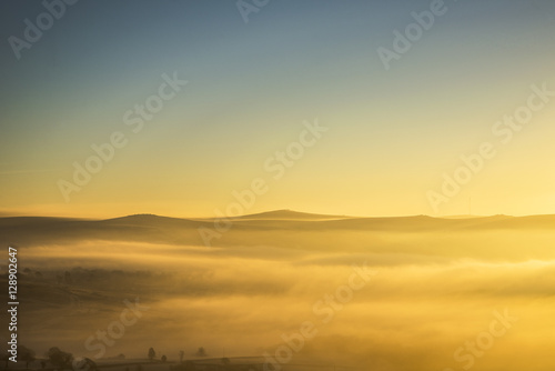 Looking over the Tors on Dartmoor on a misty golden winter sunrise, Devon ,Uk