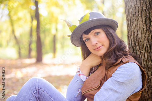 woman in hat sitting in the woods