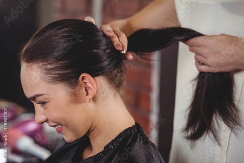 Female hairdresser styling customers hair