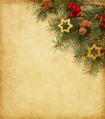 Vintage paper with spruce branch adorned with Christmas decorations.