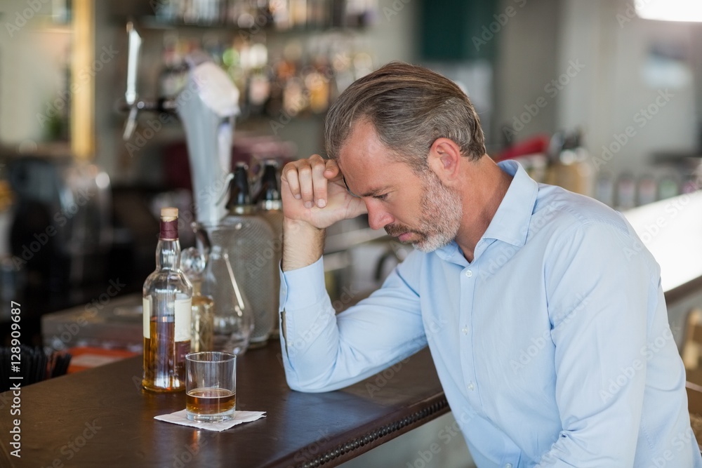 Tired man leaning his elbow on the counter Tired man leaning his elbow on the counter