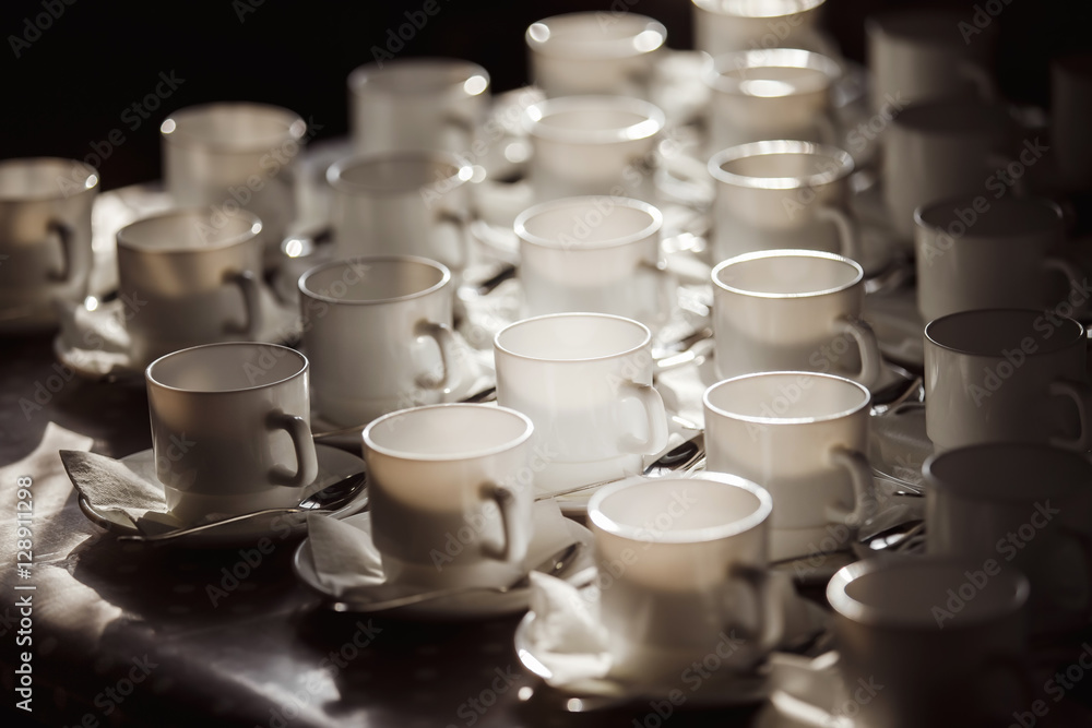 Closeup image of white cups at blurred table background. Closeup image of white cups at blurred table background.