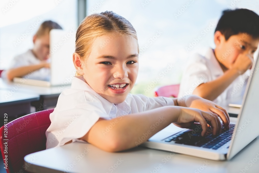 Schoolkids using laptop in classroom Schoolkids using laptop in classroom