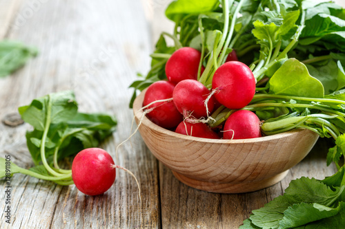 Red radishes in a wooden bowl.