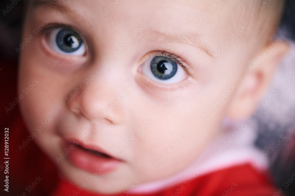 Cute baby looking straight up into the camera above him, shot very close up while he wears a red outfit for christmas. Cute baby looking straight up into the camera above him, shot very close up while he wears a red outfit for christmas.