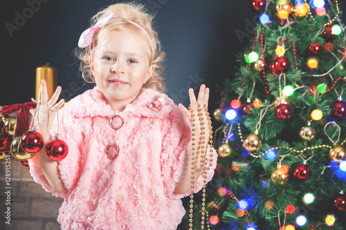 Fashion little girl decorating Christmas tree photo