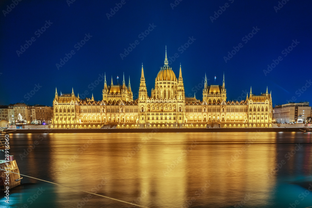 Budapest Parliament building at night on the Danube river in Hungary.
