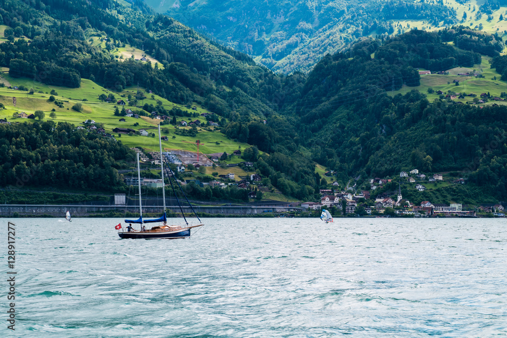 View acress the lake on a cloudy day with mountains in the backg