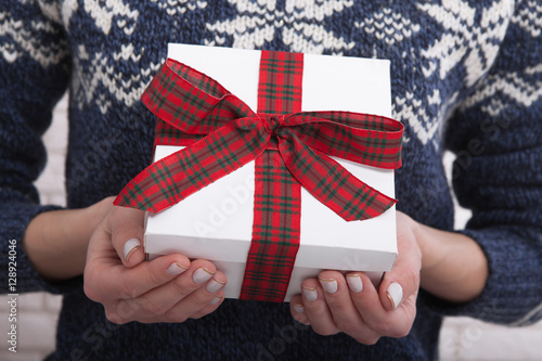 Female hands holding gift box with ribbon.