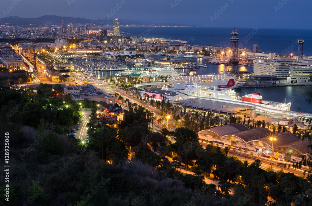 Detailed panoramic view on night illumination of Barcelona port with cruising liners, Spain