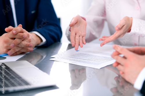 Group of business people and lawyers discussing contract papers sitting at the table, close up © rogerphoto