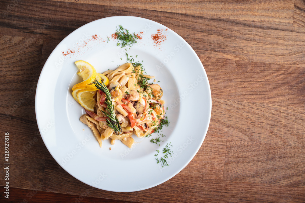 Concept: restaurant menus, healthy eating, homemade, gourmands, gluttony. Pasta with seafood on weathered wooden background. Top-down view. Concept: restaurant menus, healthy eating, homemade, gourmands, gluttony. Pasta with seafood on weathered wooden background. Top-down view.