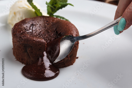 Concept: restaurant menus, healthy eating, homemade, gourmands, gluttony. White plate with chocolate fondant and ice cream on a messy vintage wooden background. photo
