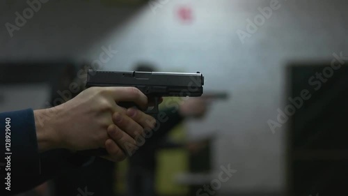 man shoots a gun at shooting range.