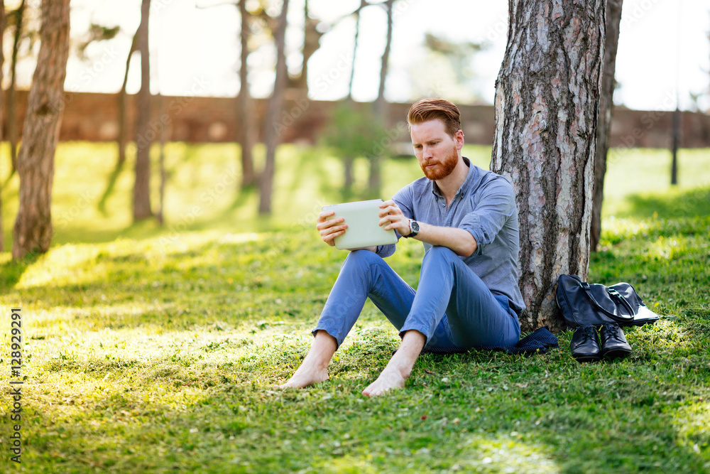 Businessman using tablet in park