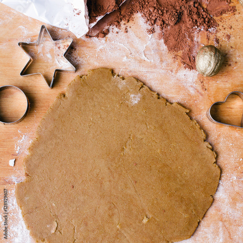 Cookies forms and gingerbread dough on wooden pastry board photo