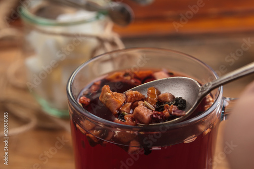 Concept: restaurant menus, healthy eating, homemade, gourmands, gluttony. Hibiscus tea with fruit pieces and sugar in glass jar on vintage wooden background.