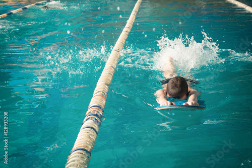 Little boy swimming in pool.
