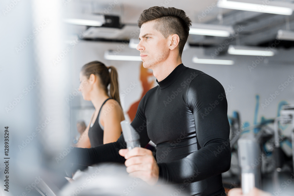 Young healthy group of people working out on a elliptic trainer Young healthy group of people working out on a elliptic trainer