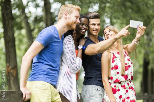 Group of young people and couples taking selfies in nature