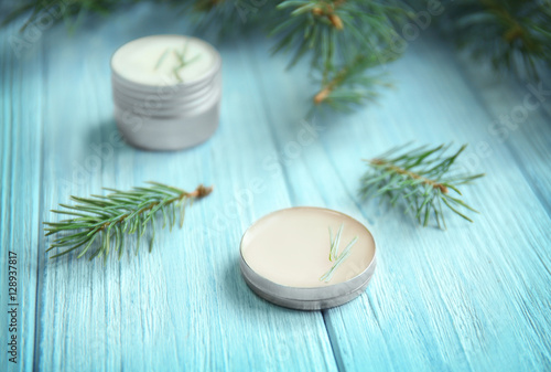 Cream and pine branches on wooden background