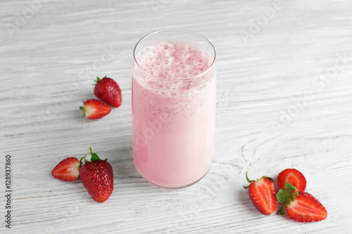 Fresh milkshake with strawberry on wooden background