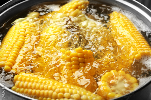 Boiling sweet corn in pan closeup