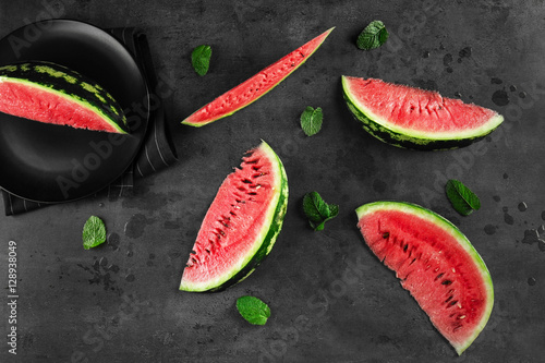 Watermelon slices with mint leaves on table