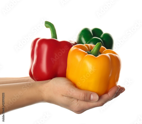 Female hands holding sweet peppers on white background
