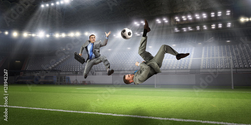Businessman playing soccer . Mixed media © Sergey Nivens