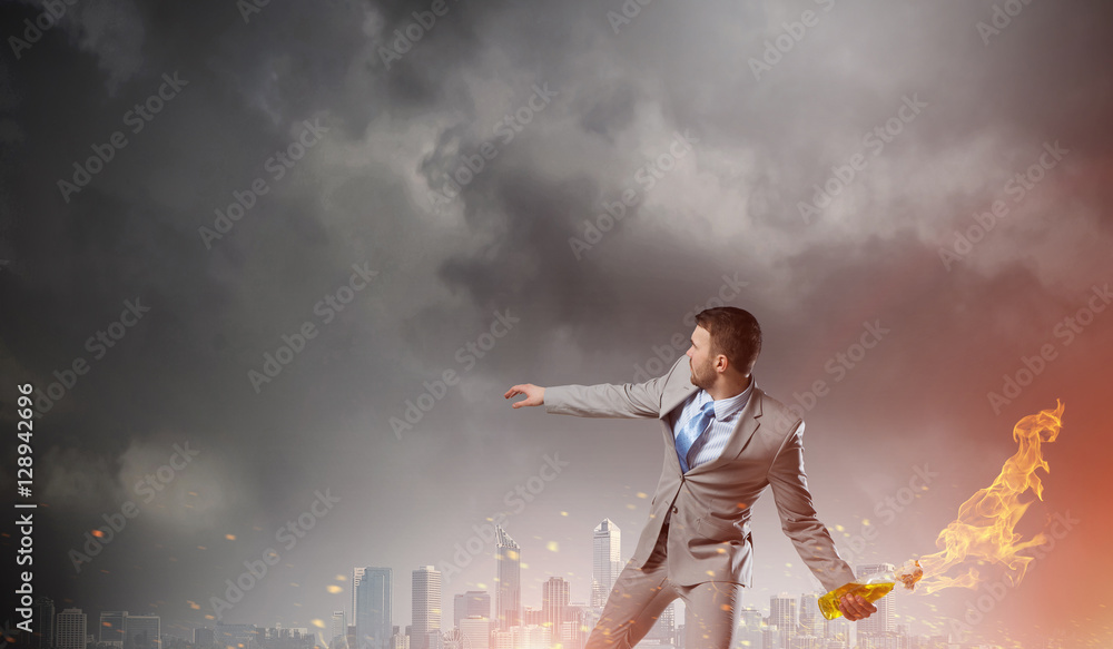 Businessman throwing petrol bomb . Mixed media Businessman throwing petrol bomb . Mixed media