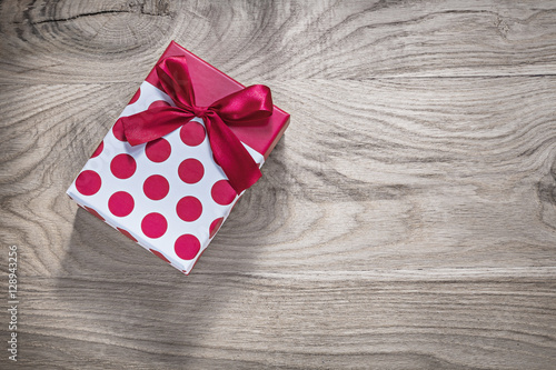 Red gift box with bow on wooden board holidays concept
