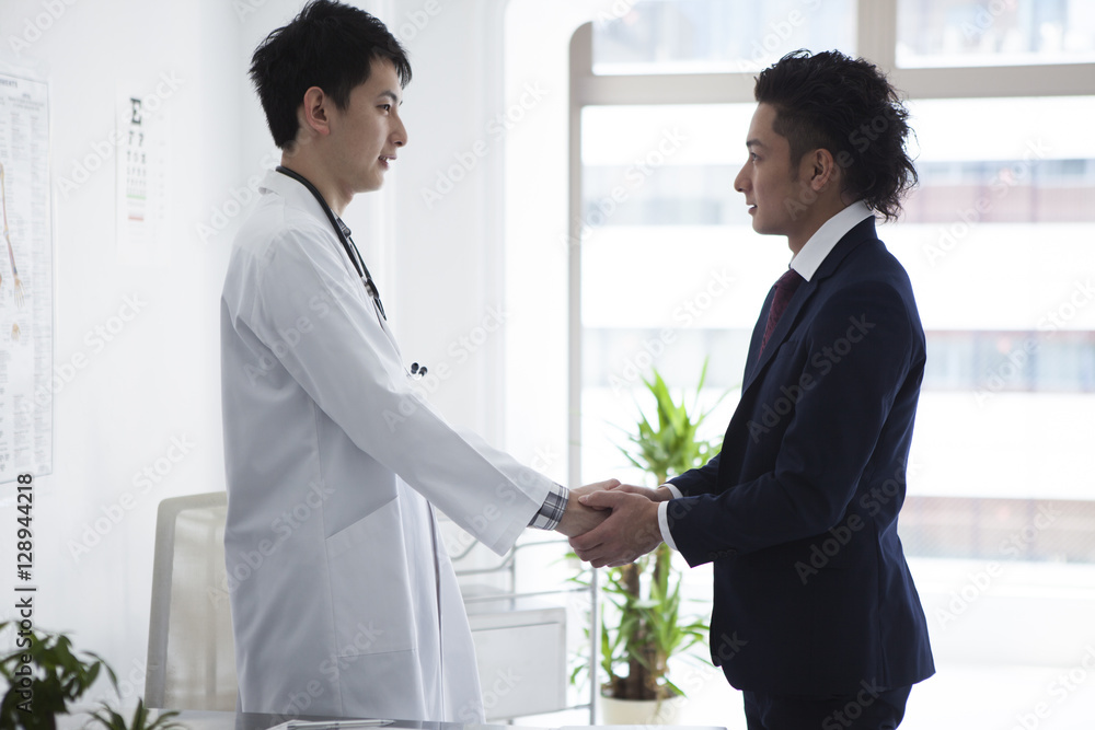Doctor and salesman of pharmaceutical company are shaking hands Doctor and salesman of pharmaceutical company are shaking hands