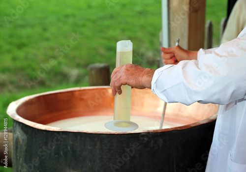 Photos expert cheesemaker pour the rennet into the cauldron to produce