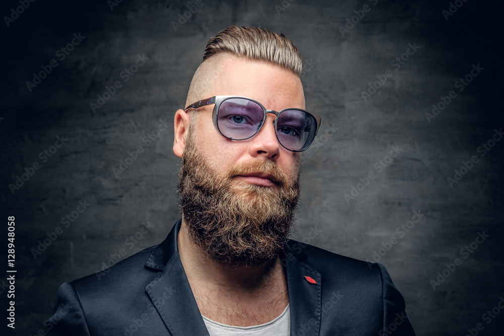 A bearded man in purple sunglasses isolated on grey vignette bac A bearded man in purple sunglasses isolated on grey vignette bac
